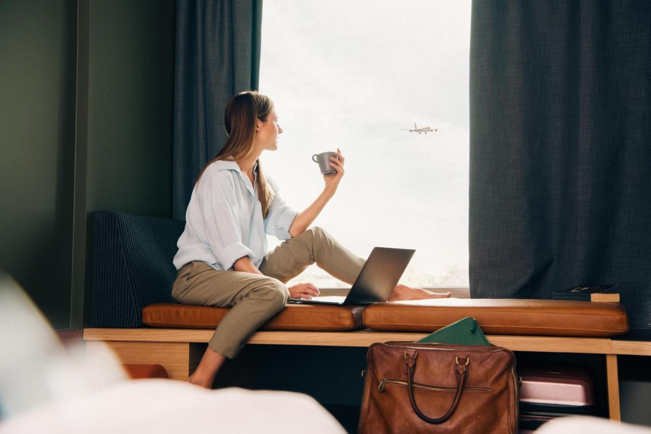 Comfort Hotel Arlanda Airport Terminal Exterior photo A woman working from home with a laptop and a suitcase.